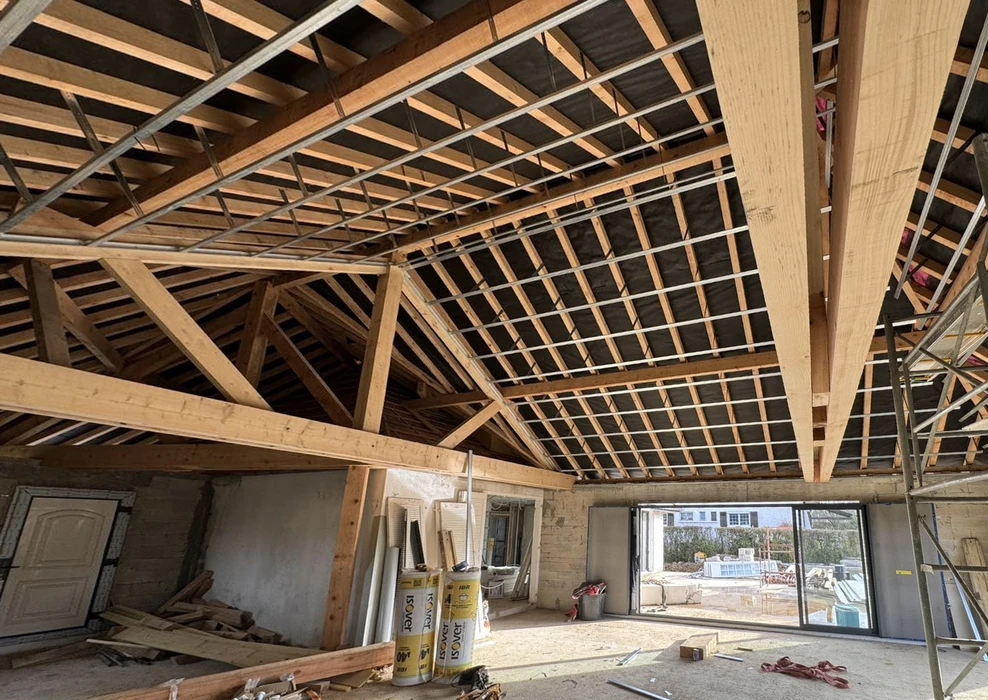 Intérieur de maison en rénovation avec charpente bois apparente