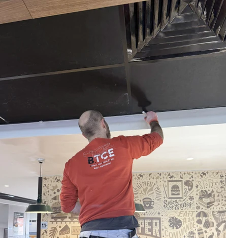 Bâtiment contemporain à architecture déconstructiviste avec façades métalliques ondulantes aux reflets violets et dorés