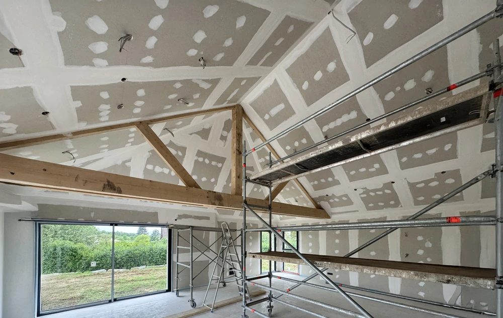 Chantier de rénovation intérieure en cours avec ouvriers en équipements de sécurité travaillant dans un espace commercial ou résidentiel