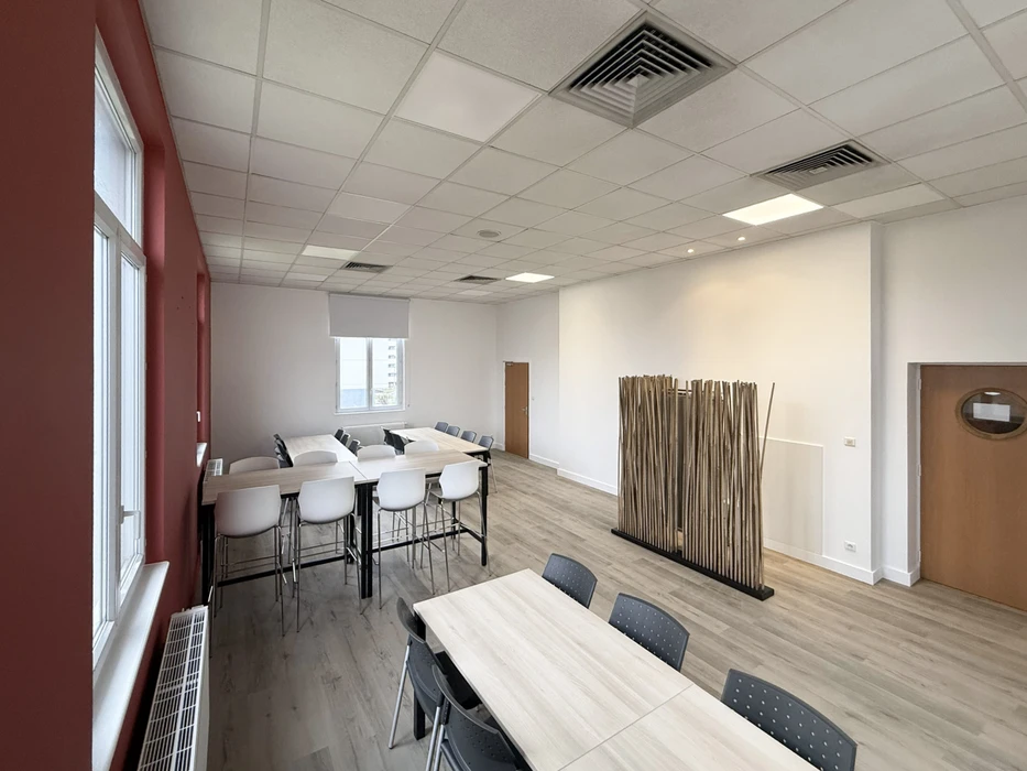 Chantier de rénovation intérieure en cours avec ouvriers en équipements de sécurité travaillant dans un espace commercial ou résidentiel