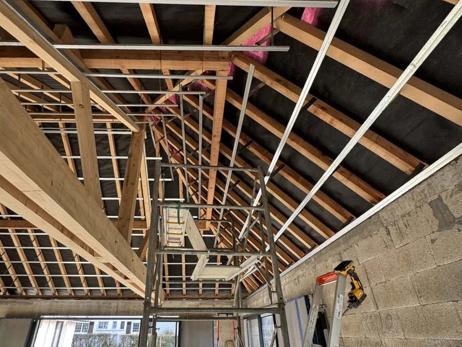 Espace de restauration d'entreprise moderne avec tables hautes et chaises, cuisine ouverte intégrée