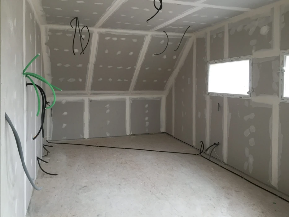 Chantier de construction intérieur en cours, espace ouvert avec ouvriers absents