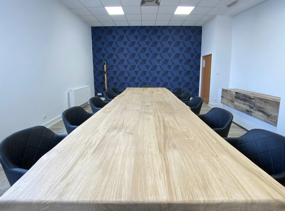 Espace de restauration d'entreprise moderne avec tables hautes et chaises, cuisine ouverte intégrée