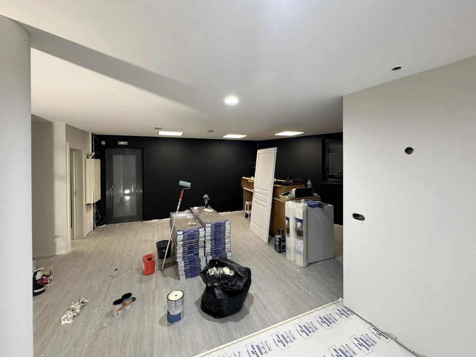 Espace de restauration d'entreprise moderne avec tables hautes et chaises, cuisine ouverte intégrée