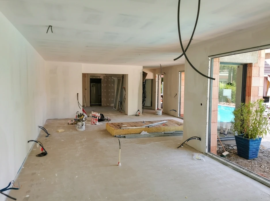 Intérieur moderne en cours de finition avec escalier contemporain à limon central et garde-corps à barreaux verticaux