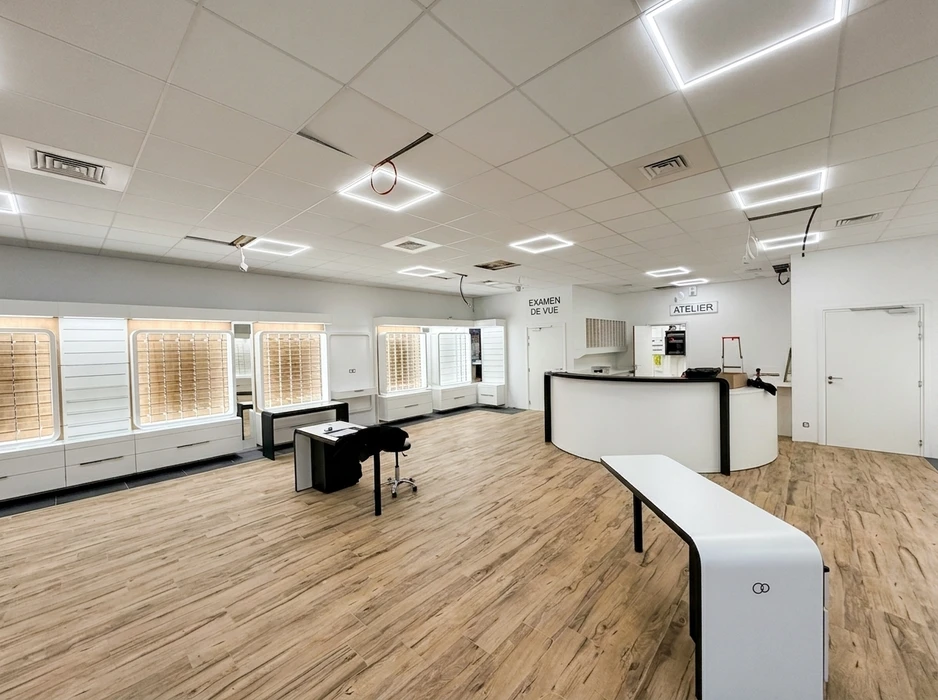 Espace de restauration d'entreprise moderne avec tables hautes et chaises, cuisine ouverte intégrée